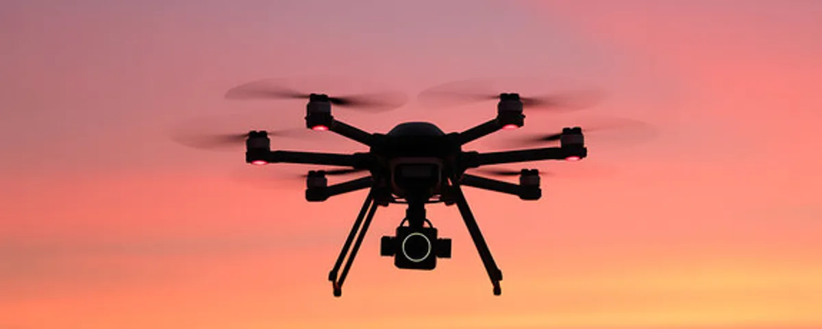 Drone silhouette against a cloudy overcast sky